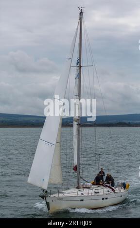 4 quattro uomini di equipaggio navigano nel Solent a bordo di una barca a vela Beneteau Oceanis 411 Clipper Fusion III sull'Isola di Wight, Hampshire, Regno Unito, a settembre Foto Stock