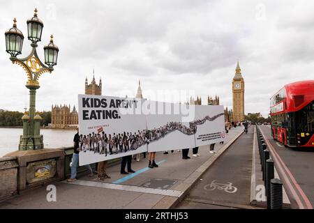 USO EDITORIALE SOLO dei giovani ambasciatori del cibo per la protesta della Fondazione alimentare a Westminster con la loro reinterpretazione di un manifesto politico nell’ambito della campagna «Feed the Future», con l’obiettivo di indurre i politici a impegnarsi a estendere l’accesso ai pasti della scuola libera, poiché 900.000 bambini che vivono in povertà non sono ammissibili al programma. Data foto: Mercoledì 23 settembre. Foto Stock