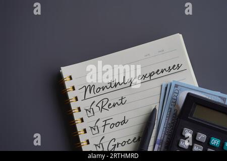 Immagine dall'alto del notebook con testo SPESE MENSILI, denaro e calcolatore. Concetto finanziario Foto Stock