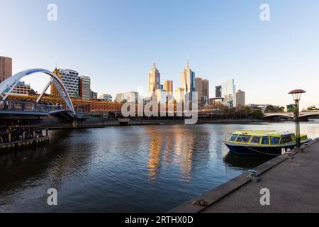 Lo skyline di Melbourne lungo il fiume Yarra al tramonto verso Federation Square Foto Stock