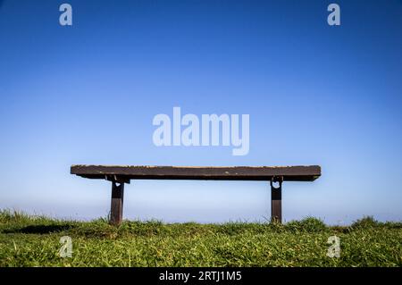 Banco in metallo su erba verde con panca con sfondo cielo azzurro Foto Stock