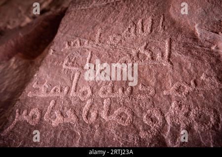 Antiche iscrizioni petroglifiche nel canyon Khazali nel deserto del Wadi Rum in Giordania, una tappa popolare per i tour in jeep nel deserto del Wadi Rum Foto Stock