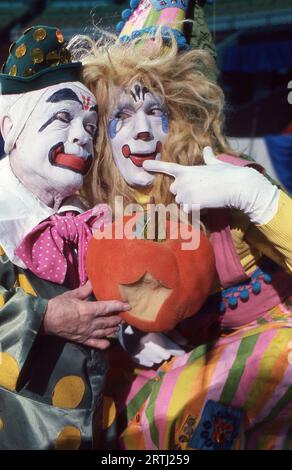 Foto di 2 clown Ringling Brothers in trucco completo con in mano una zucca che sembra essere stata morsa. Alle audizioni del Clown College nel 1979. Foto Stock