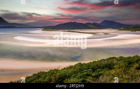 Vista dall'insenatura della collina sulla spiaggia di Whitehaven a Whitsunday Island vicino a Airlie Beach, Australia con la bassa marea. Le bellissime nuvole rosa si trovano in posizione Foto Stock