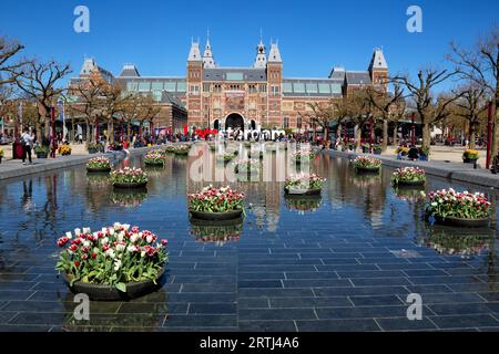 Decorazioni in tulipano riflesse nella fontana di fronte al Rijksmuseum di Amsterdam, Paesi Bassi in primavera. Tulipani colorati riflessi in un laghetto Foto Stock