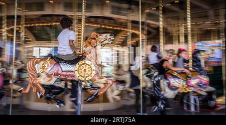 St Kilda, Melbourne, Australia su ami 14, 2016: Kid a cavallo sulla vecchia giostra francese Foto Stock