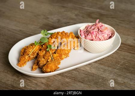 Strisce di pollo fritte con insalata di cavolo Foto Stock