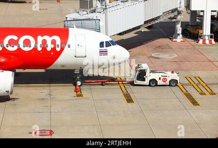 Gli aerei si spingono indietro con l'aereo i rimorchiatori verso la via di rullaggio, uno nei servizi di assistenza a terra. Foto Stock