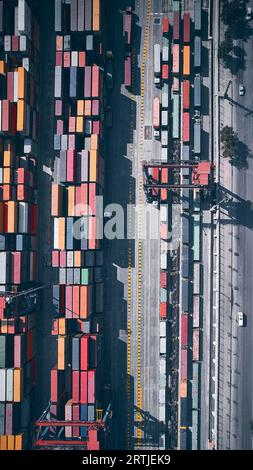 Vista aerea dall'alto verso il basso dei contenitori di carico impilati. Container presso il terminal logistico. Magazzino esterno per container da carico Foto Stock