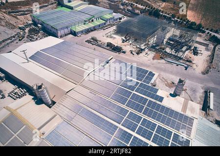 Vista aerea degli edifici industriali con pannelli fotovoltaici installati sul tetto. Pannelli solari sul tetto di edifici industriali. Vista aerea pannelli fotovoltaici solari Foto Stock