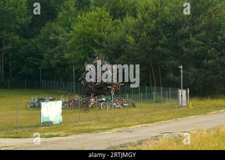 Una montagna di vecchie biciclette si trova in un'area verde. Foto Stock