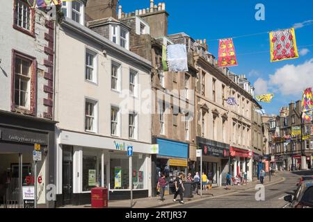 Gente che cammina lungo Arbroath High Street, Angus, Scozia, Regno Unito Foto Stock