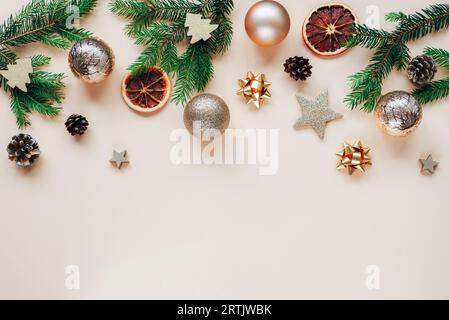 Sfondo natalizio e Capodanno. Rami, palle e baule dell'albero di Natale su sfondo beige. Vista dall'alto, base piatta, spazio di copia. Foto Stock