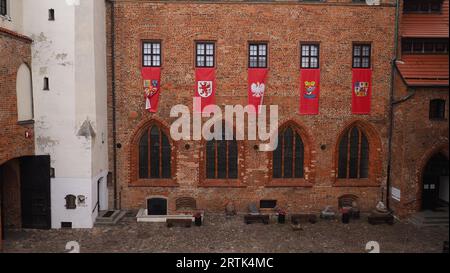 Il cortile del castello di Darlowo, Polonia - sul lato destro ci sono bandiere con stemma Foto Stock