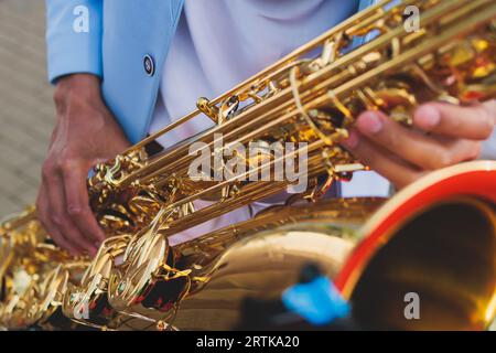 Vista da concerto del sassofonista in costume blu e bianco, sax con cantante e gruppo musicale durante lo spettacolo dell'orchestra jazz che esegue musica Foto Stock