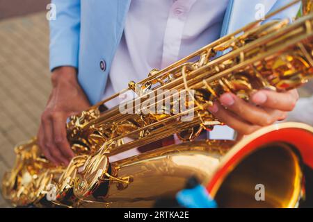 Vista da concerto del sassofonista in costume blu e bianco, sax con cantante e gruppo musicale durante lo spettacolo dell'orchestra jazz che esegue musica Foto Stock