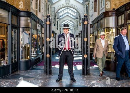 Un Beadle vestito in costume tradizionale si trova all'ingresso di Burlington Arcade, Londra, Regno Unito. Foto Stock