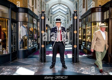 Un Beadle vestito in costume tradizionale si trova all'ingresso di Burlington Arcade, Londra, Regno Unito. Foto Stock