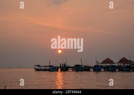 Vista delle barche al porto della spiaggia di Kartini al tramonto. Foto Stock
