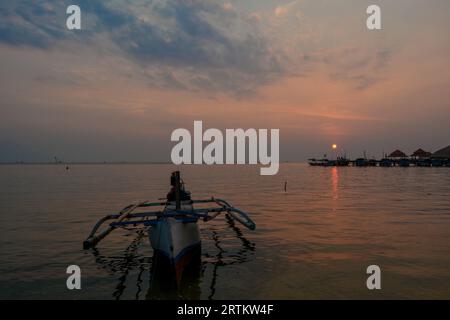Vista delle barche al porto della spiaggia di Kartini al tramonto. Foto Stock