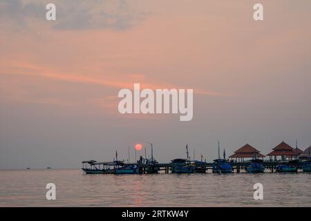 Vista delle barche al porto della spiaggia di Kartini al tramonto. Foto Stock