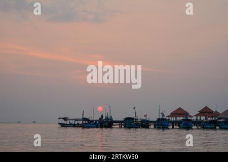 Vista delle barche al porto della spiaggia di Kartini al tramonto. Foto Stock