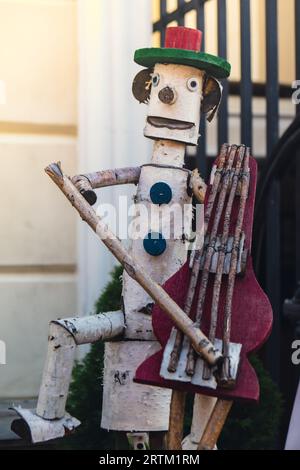 Pinocchio burattino di legno che suona strumento musicale. Mercato d'antiquariato e usato nella piazza principale. Pinocchio, burattini. Foto Stock