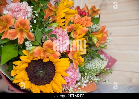 Bouquet autunnale con fiori da giardino. Bellissimo bouquet autunnale su un tavolo di legno. Dalie colorate, alstroemeria e crisantemi. Foto Stock