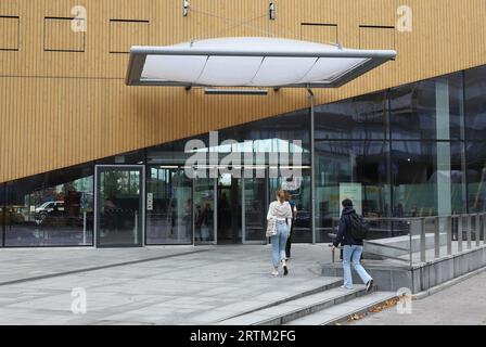 Helsinki, Finlandia - 5 settembre 2023: I visitatori camminano verso l'ingresso della biblioteca centrale di Helsinki Oodi. Foto Stock