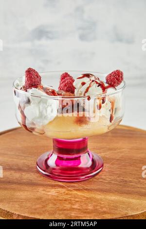 Pesche con lamponi, gelato alla vaniglia, marmellata di frutta e mandorle Foto Stock