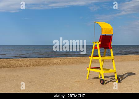 Sedia bagnino vuota sulla spiaggia del mare. Equipaggiamento di salvataggio per supportare l'osservazione di persone che giocano in acqua. Foto scattata a mezzogiorno in un soleggiato Foto Stock