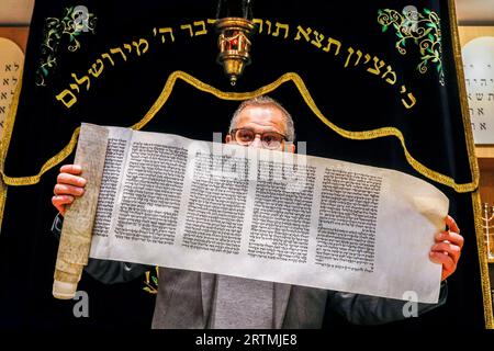 Celebrazione del Purim nella sinagoga di Beth Yaacov, Parigi, Francia. Rabbi Gabriel Farhi mostra il rotolo del libro di Ester Foto Stock