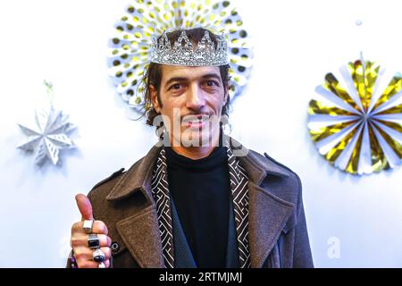 Tradizionale celebrazione dell'Epifania a la Maison Bakhita, Parigi, Francia. Migrante tunisino che indossa una corona di cartone Foto Stock