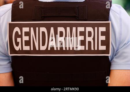 Segno di Gendarmerie da primo piano scritto sul retro di un gilet antiproiettile indossato da un gendarme francese in strada. Francia. Foto Stock