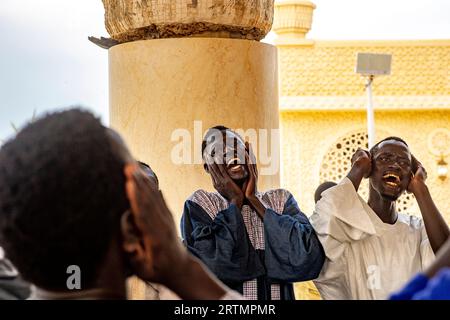 I devoti cantano versi coranici nella grande moschea di Touba, in Senegal Foto Stock