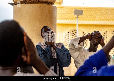 I devoti cantano versi coranici nella grande moschea di Touba, in Senegal Foto Stock