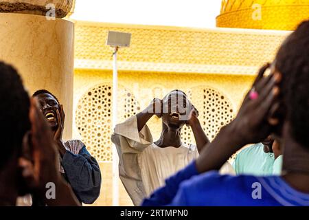 I devoti cantano versi coranici nella grande moschea di Touba, in Senegal Foto Stock