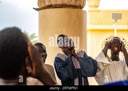 I devoti cantano versi coranici nella grande moschea di Touba, in Senegal Foto Stock