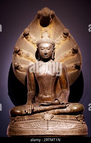 Museo Nazionale di Bangkok. Buddha in meditazione sotto sette teste Naga. xiv secolo. Provincia di Suratthani. Thailandia. Foto Stock