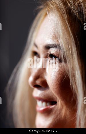 Ritratto di bella donna asiatica con lunghi capelli biondi e trucco. Foto Stock