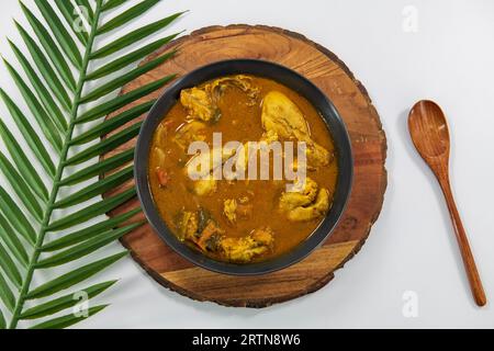 Pollo al curry o masala o pollo rustico in stile kuzhambu Tamilnadu , curry di pollo con olio di cocco fritto in modo tradizionale e decorato in bianco Foto Stock