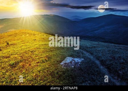 sentiero stretto attraverso prati erbosi tra pietre bianche in cima alla collina in alta montagna con sole e luna al crepuscolo. cambio orario giorno e notte conc Foto Stock