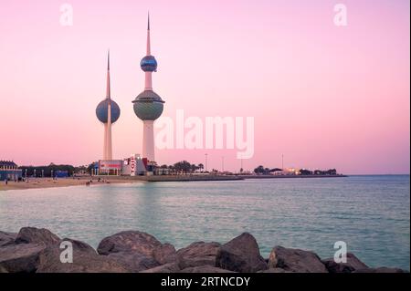 Vista dello skyline del Kuwait - con il più famoso punto di riferimento della città di Kuwait - durante il tramonto Foto Stock