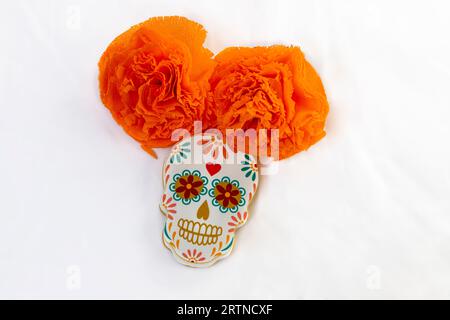 Biscotti con forme di catrinas messicane e fiori di calendula d'arancia per celebrare Halloween o il giorno dei morti su sfondo bianco Foto Stock
