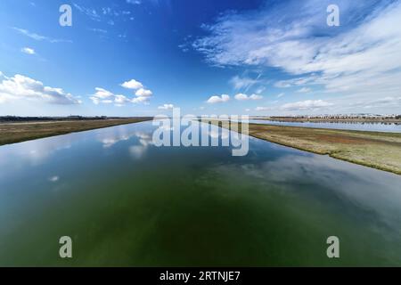 Vista aerea con droni della foce del fiume Tinto. Estuario del Rio Tinto nelle paludi di Huelva con un bel riflesso del cielo Foto Stock