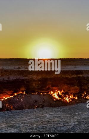 Abbiamo trascorso la notte in campeggio presso il cratere a gas Darvaza e ci siamo svegliati con un'alba gloriosa sul Karakum, dove il cielo e il suolo sono bruciati Foto Stock