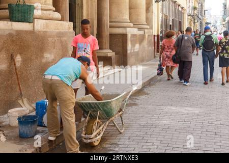 L'Avana, Cuba - 30 agosto 2023: Un muratore lavora sulla facciata di un vecchio edificio. Foto Stock