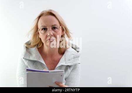 Immagine di una donna, di un'azienda che lavora negli occhiali, sorride e tiene un tablet digitale, in piedi su sfondo bianco. Foto di alta qualità Foto Stock