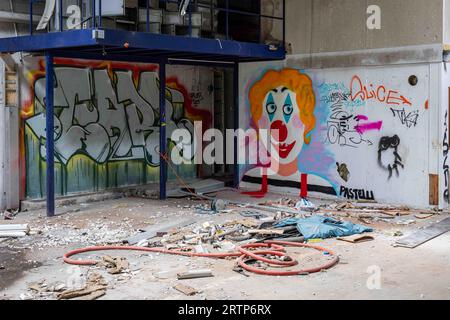 Fabbrica abbandonata con graffiti sul muro e detriti sul pavimento a Paimio, Finlandia Foto Stock