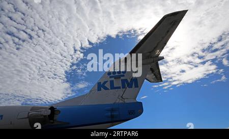 Schiphol, Paesi Bassi - 14 agosto 2023: La coda di un aereo Fokker 100 della KLM contro un cielo blu con nuvole Foto Stock